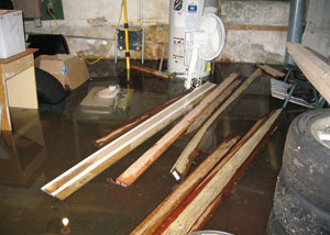 A severely flooding basement in Meridian, with lumber and personal items floating in a foot of water