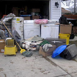 Soaked, wet personal items sitting in a driveway, including a washer and dryer in Logan.