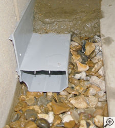 A no-clog basement french drain system installed in Sandy